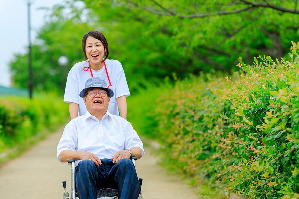 휠체어를 미는 사람도 탄 사람도 웃는 사진