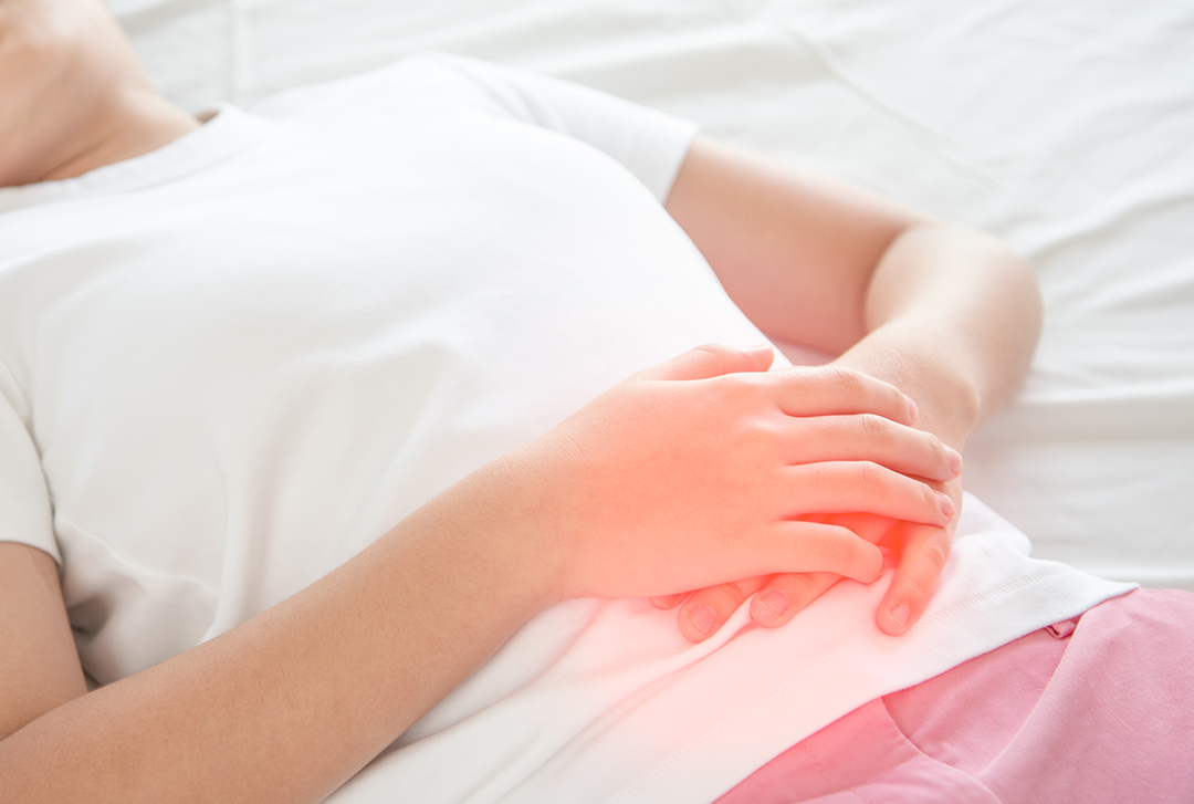 배의 통증 부위를 손으로 덮고 있는 사진